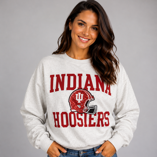 Model wearing the Indiana Hoosiers Football Slouchy Drop Shoulder Crewneck in oatmeal heather, featuring red Indiana Hoosiers lettering and a crimson sequin football helmet graphic.