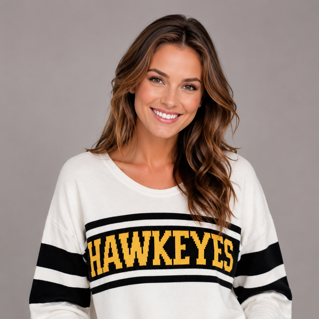 Close-up of a model wearing the Iowa Hawkeyes Knit V-Neck Sweater in ivory, featuring black varsity sleeve stripes and bold gold HAWKEYES lettering across the chest.