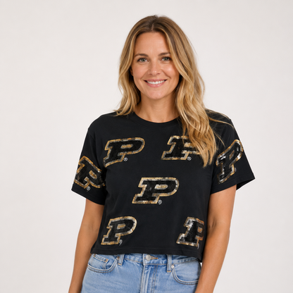 Model wearing a black Purdue Sequin Tee featuring an all-over pattern of shimmering black and light gold sequin Purdue “P” logos.