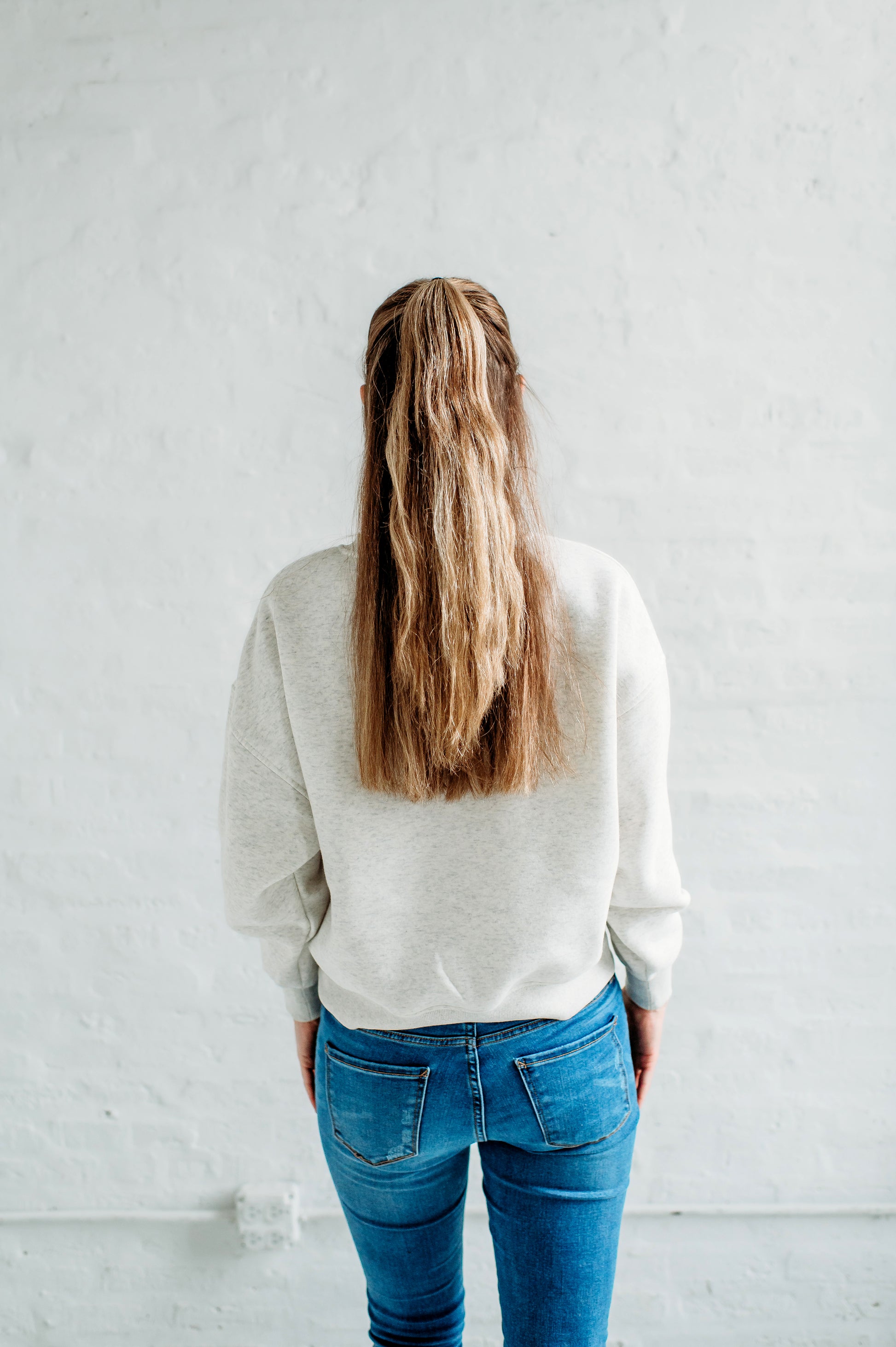 Back view of a model wearing the Iowa State Football Slouchy Drop Shoulder Crewneck in oatmeal heather.